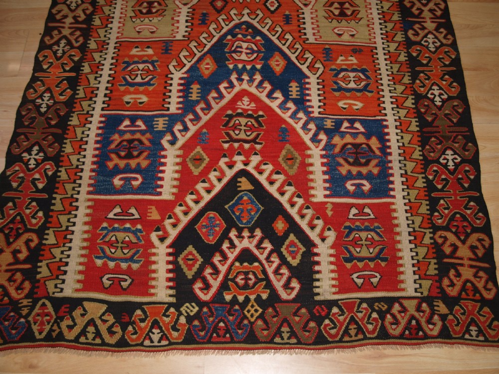 An antique Turkish Konya flatweave prayer kilim featuring a stepped mihrab pattern in red, blue, terracotta, and beige wool. View VI