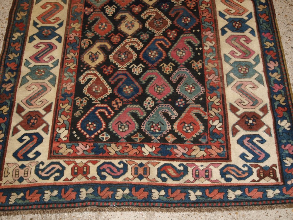 An antique 19th-century Caucasian Karabagh hallway runner carpet featuring colourful repeated boteh motifs across a dark central field framed by ivory geometric borders. View VII