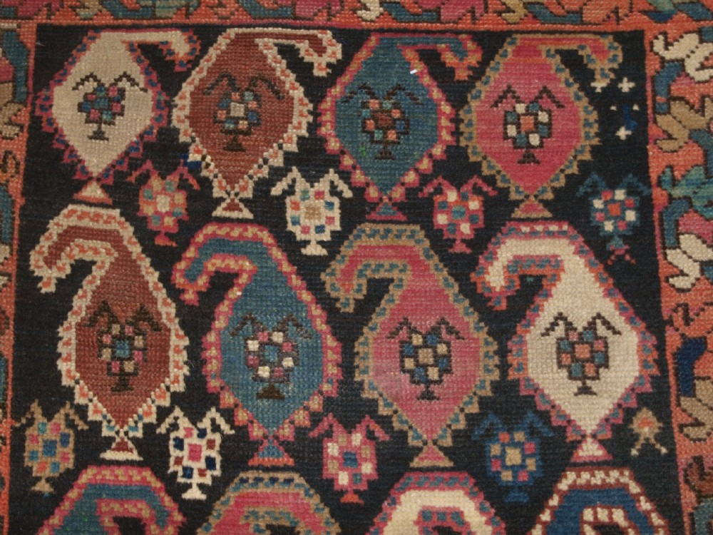 An antique 19th-century Caucasian Karabagh hallway runner carpet featuring colourful repeated boteh motifs across a dark central field framed by ivory geometric borders. View VIII