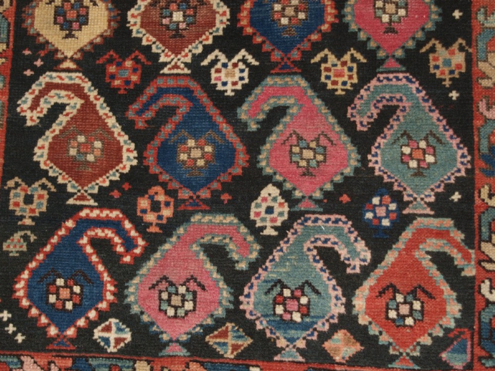 An antique 19th-century Caucasian Karabagh hallway runner carpet featuring colourful repeated boteh motifs across a dark central field framed by ivory geometric borders. View IX