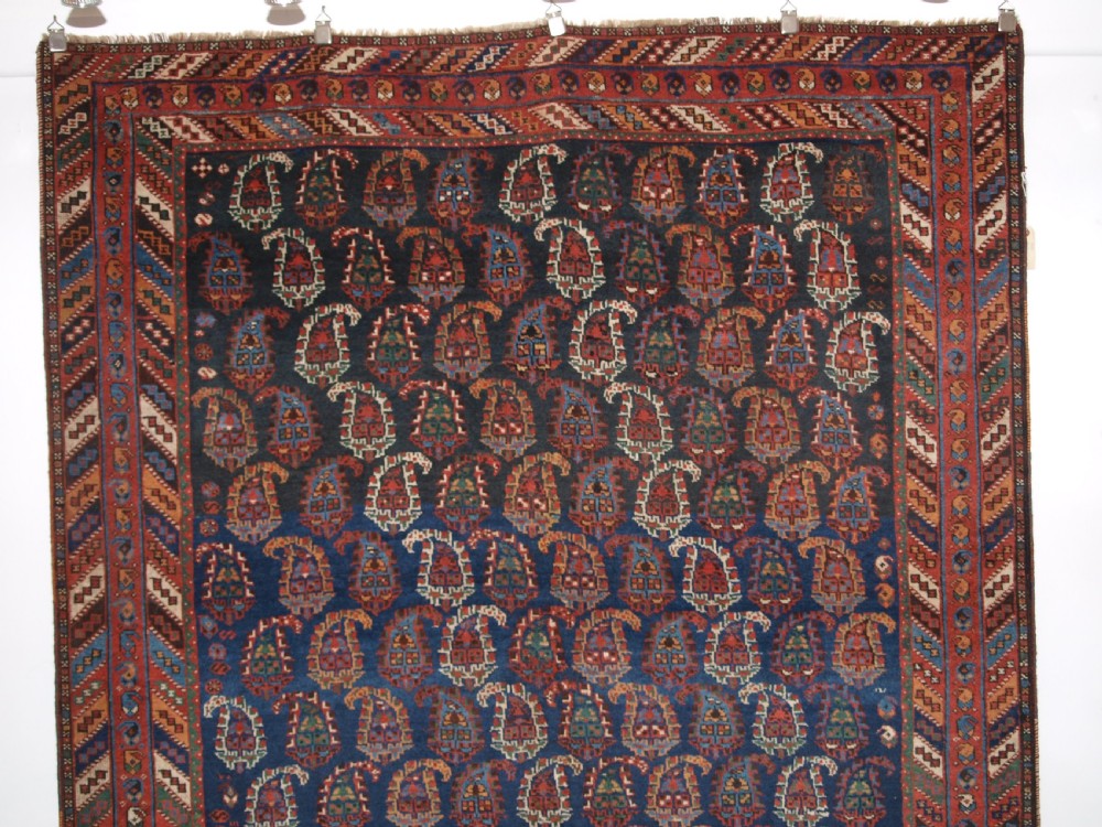 An antique Afshar long rug featuring a dark navy blue central field densely filled with repeating multi-coloured boteh motifs, bordered by geometric stripes. View II