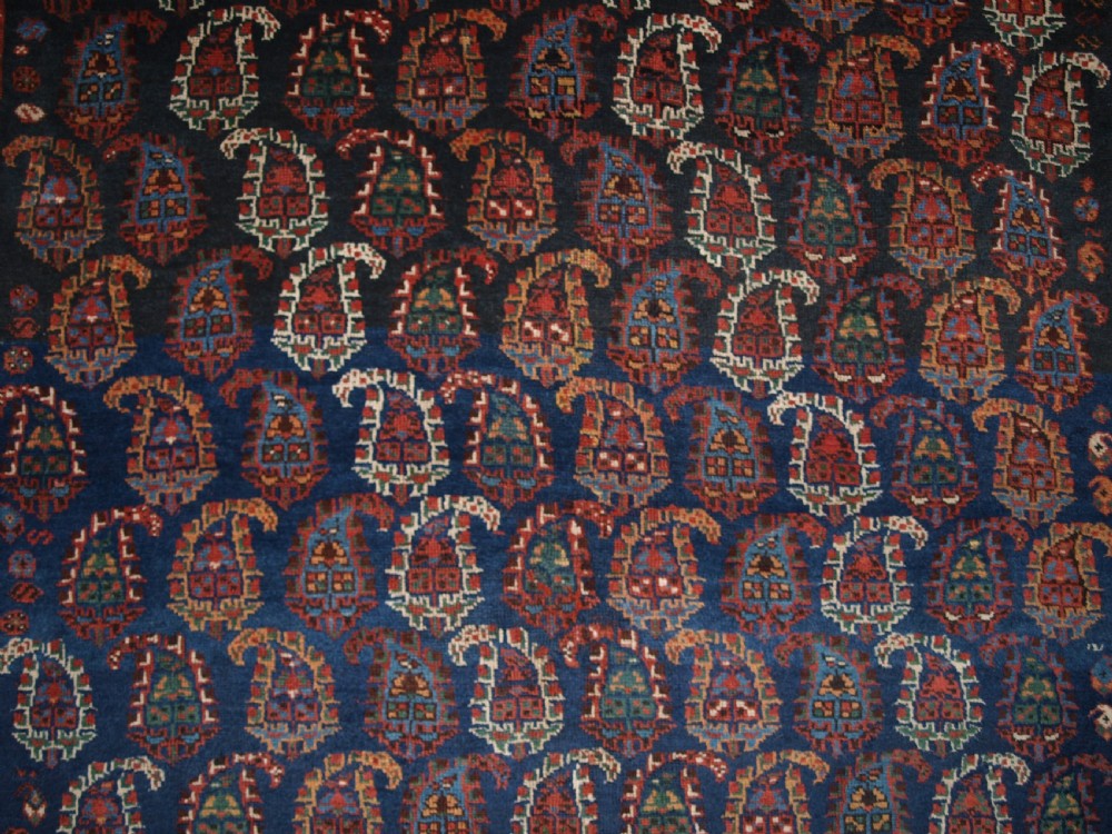 An antique Afshar long rug featuring a dark navy blue central field densely filled with repeating multi-coloured boteh motifs, bordered by geometric stripes. View VIII