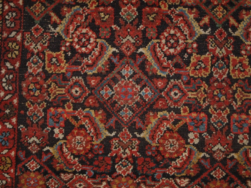 An antique hand-knotted Malayer rug displaying a detailed dark navy and red Herati lattice pattern framed by an ivory floral border. View V