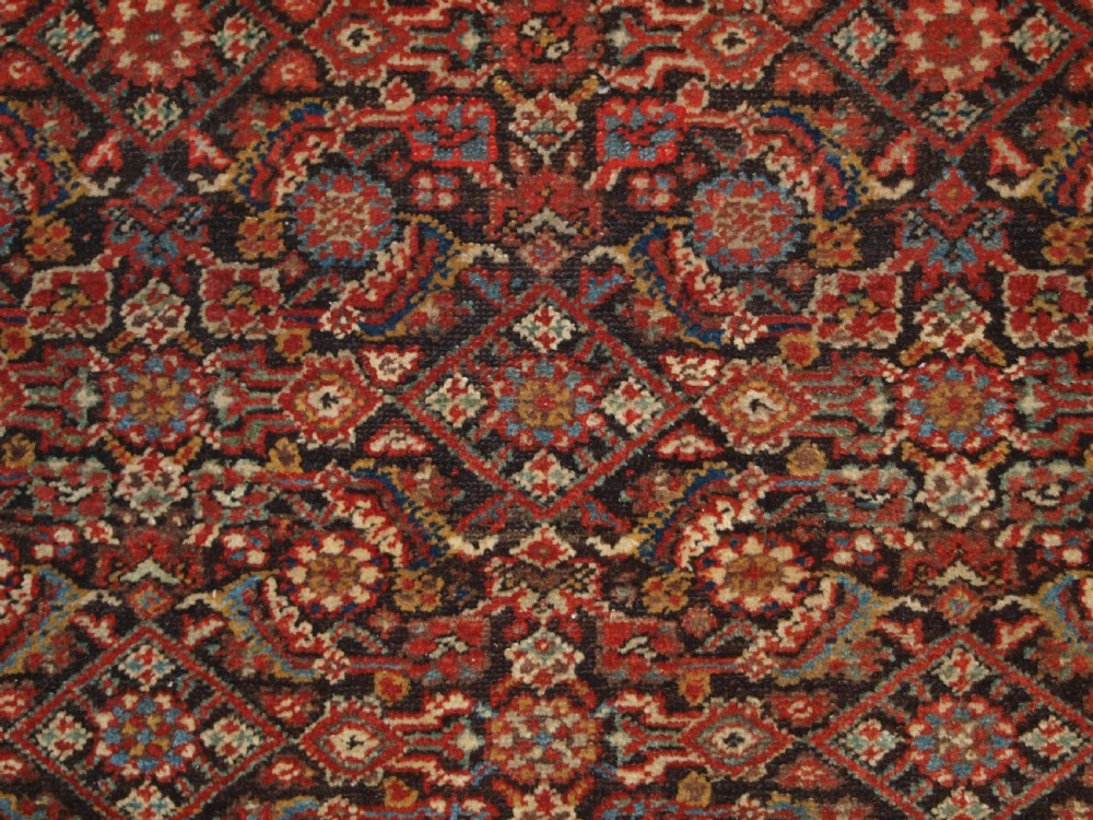 An antique hand-knotted Malayer rug displaying a detailed dark navy and red Herati lattice pattern framed by an ivory floral border. View VI