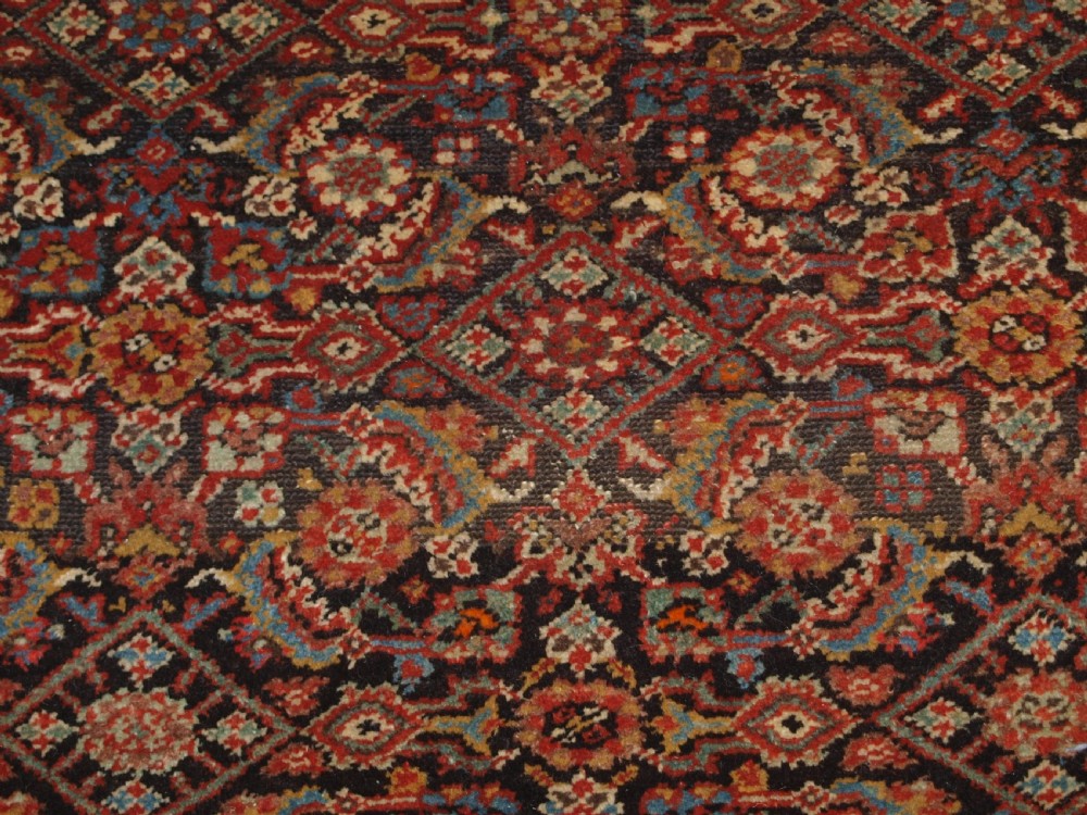 An antique hand-knotted Malayer rug displaying a detailed dark navy and red Herati lattice pattern framed by an ivory floral border. View VII