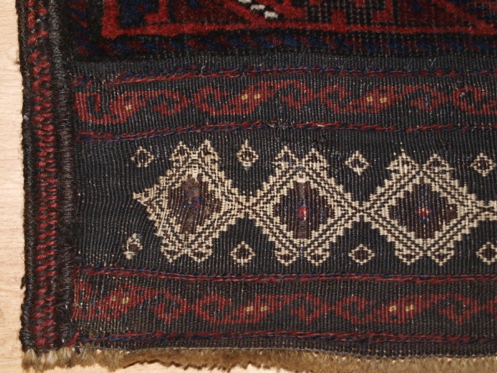 An antique hand-knotted wool carpet featuring deep blue and dark red geometric octagonal medallions inside layered decorative borders. View X
