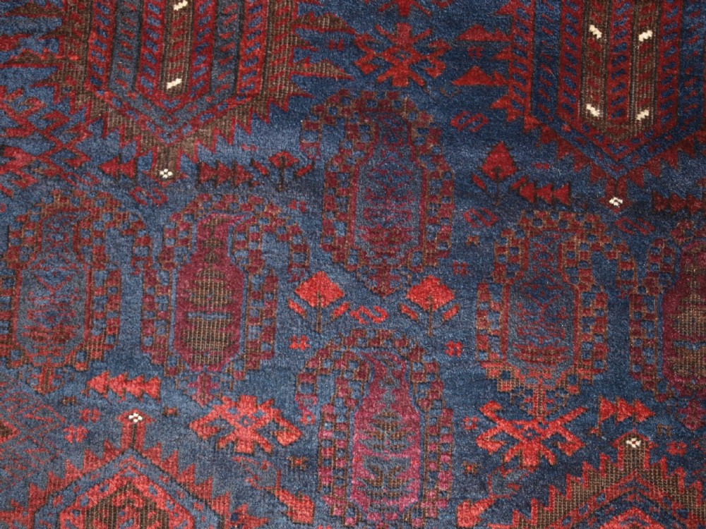 An antique hand-knotted wool carpet featuring deep blue and dark red geometric octagonal medallions inside layered decorative borders. View XI