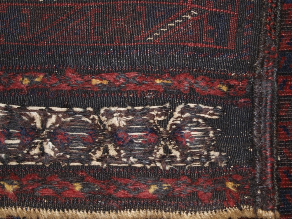 An antique hand-knotted wool carpet featuring deep blue and dark red geometric octagonal medallions inside layered decorative borders. View XII