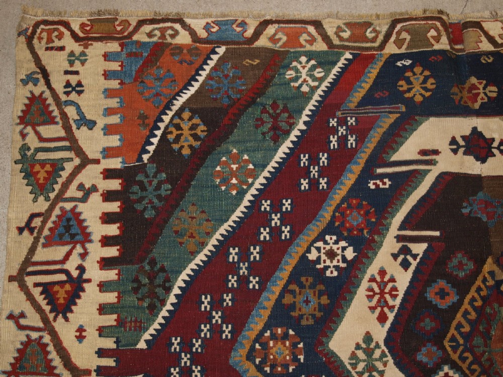A late 19th-century handwoven Turkish Malatya kilim rug featuring complex geometric diamond medallions in terracotta red, navy blue, green, and cream wool. View III