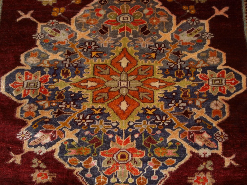 An antique hand-knotted Turkish Avanos wool rug featuring a deep burgundy red field with a central geometric medallion and cream floral border. View XI