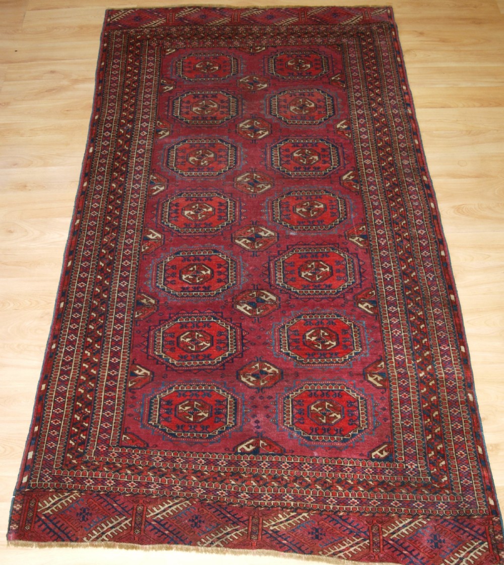 ANTIQUE TEKKE TURKMEN RUG WITH SALOR GULS, COCHINEAL COLOUR, CIRCA 1890.