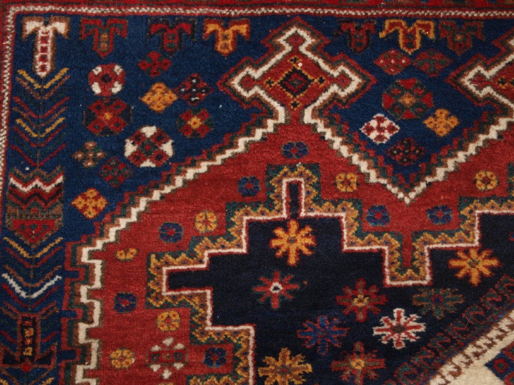 A hand-knotted antique Persian Afshar rug featuring three stacked diamond medallions surrounded by geometric floral motifs in navy blue, terracotta red, and ivory tones. View VIII