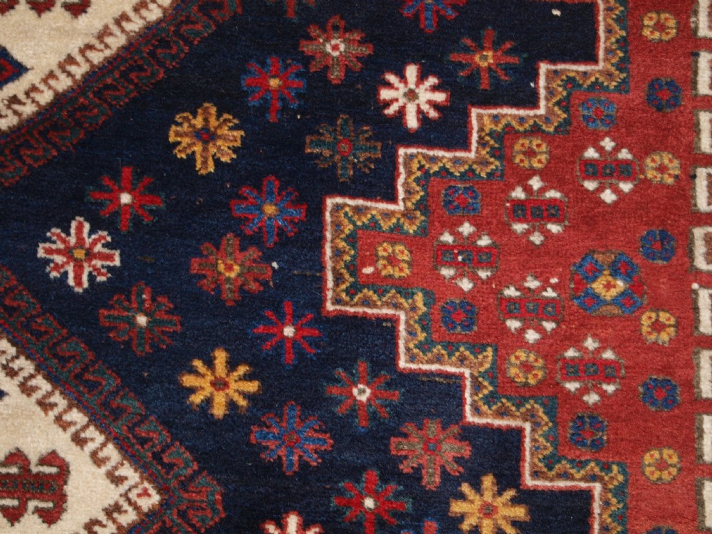 A hand-knotted antique Persian Afshar rug featuring three stacked diamond medallions surrounded by geometric floral motifs in navy blue, terracotta red, and ivory tones. View XI