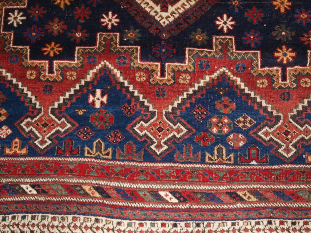 A hand-knotted antique Persian Afshar rug featuring three stacked diamond medallions surrounded by geometric floral motifs in navy blue, terracotta red, and ivory tones. View XII