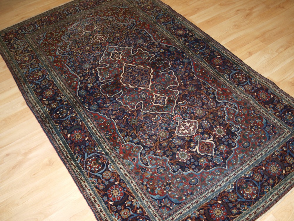 A hand-knotted Persian Kork Kashan wool rug featuring a central medallion with intricate floral motifs in navy blue, red, and cream. View II