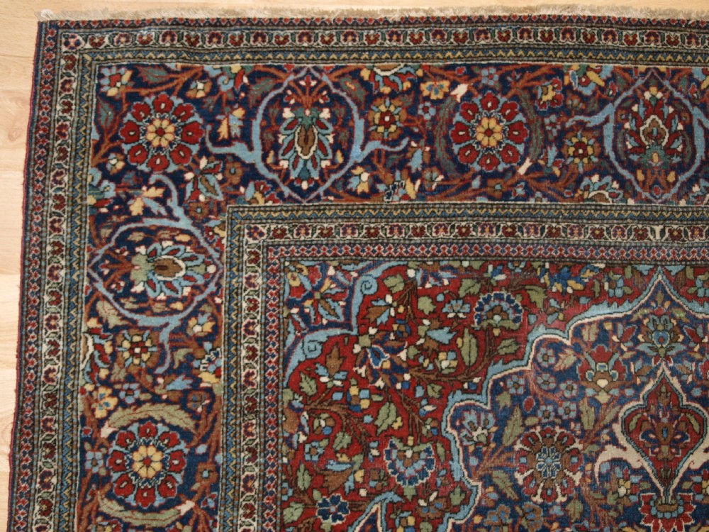 A hand-knotted Persian Kork Kashan wool rug featuring a central medallion with intricate floral motifs in navy blue, red, and cream. View III