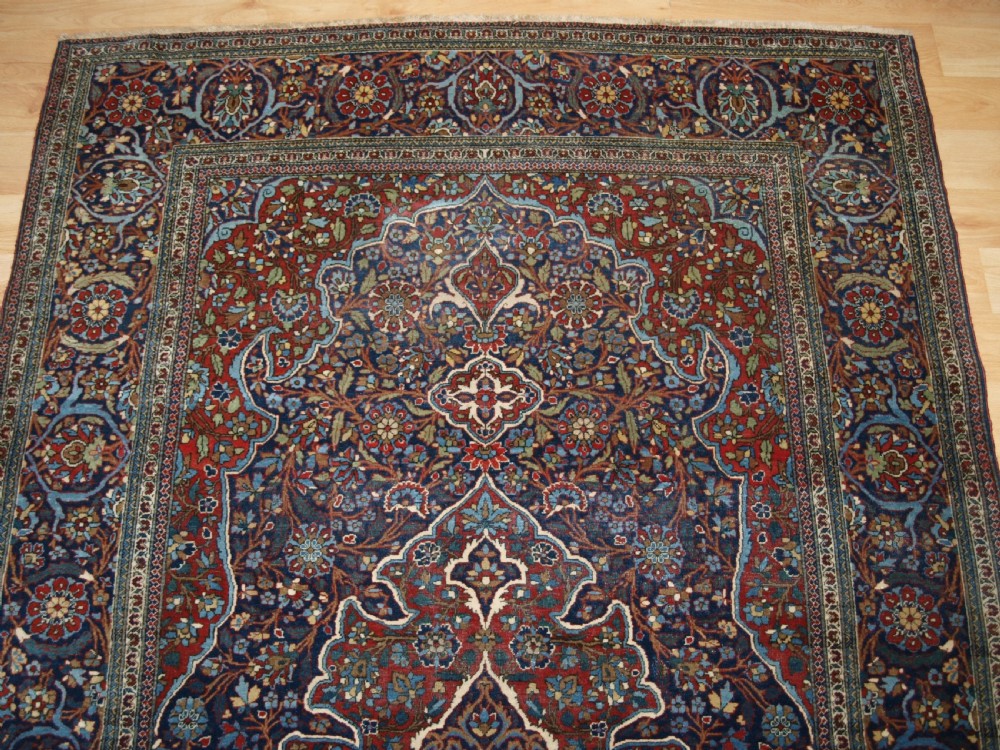 A hand-knotted Persian Kork Kashan wool rug featuring a central medallion with intricate floral motifs in navy blue, red, and cream. View IV