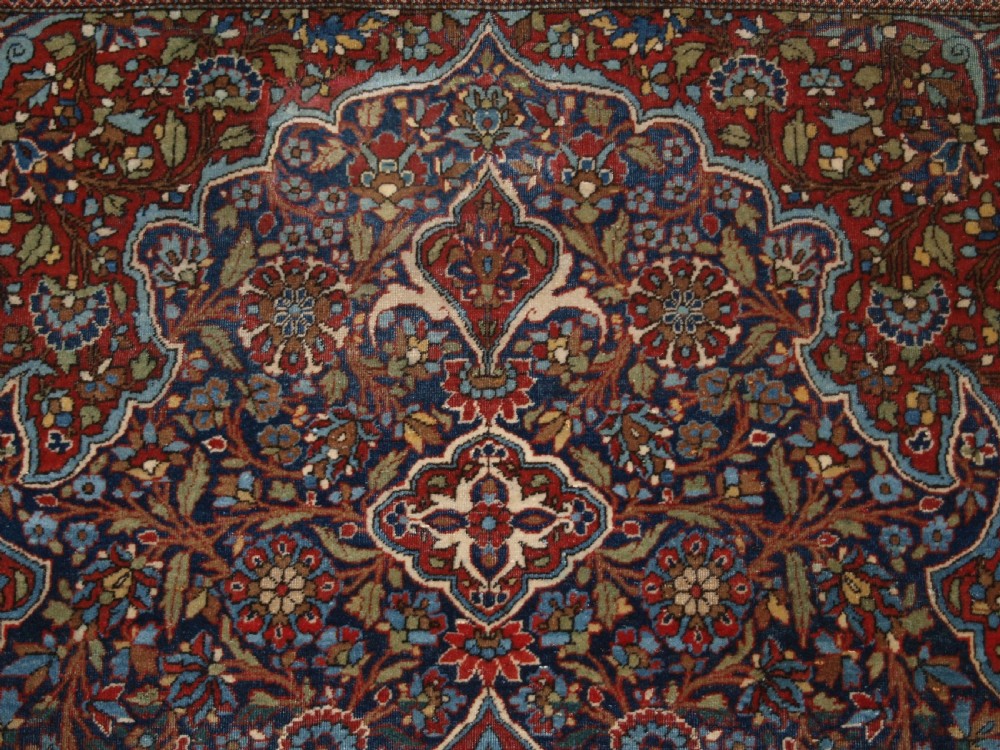 A hand-knotted Persian Kork Kashan wool rug featuring a central medallion with intricate floral motifs in navy blue, red, and cream. View VII