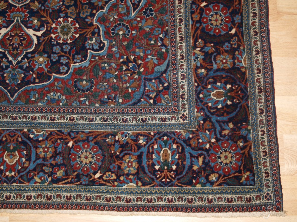 A hand-knotted Persian Kork Kashan wool rug featuring a central medallion with intricate floral motifs in navy blue, red, and cream. View VIII