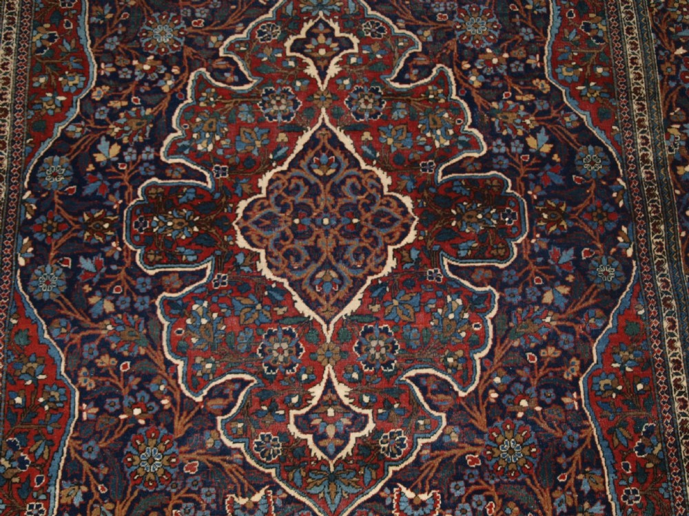 A hand-knotted Persian Kork Kashan wool rug featuring a central medallion with intricate floral motifs in navy blue, red, and cream. View IX