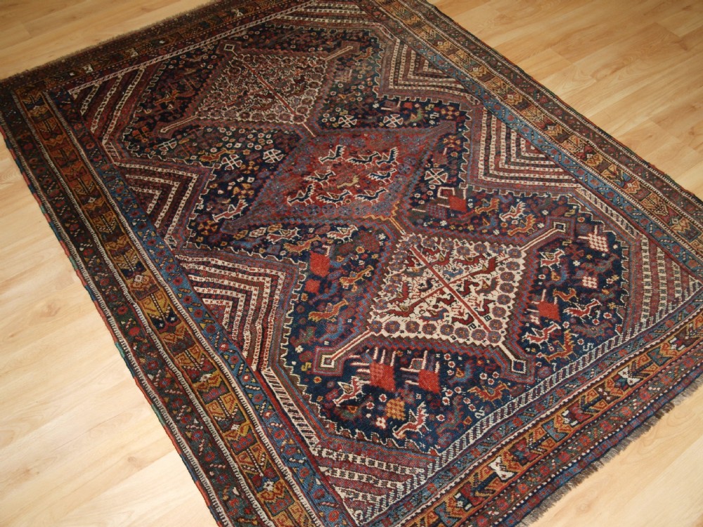 An antique hand-knotted Persian Khamseh wool rug featuring triple diamond medallions filled with stylized bird motifs on a dark navy and red geometric field. View II