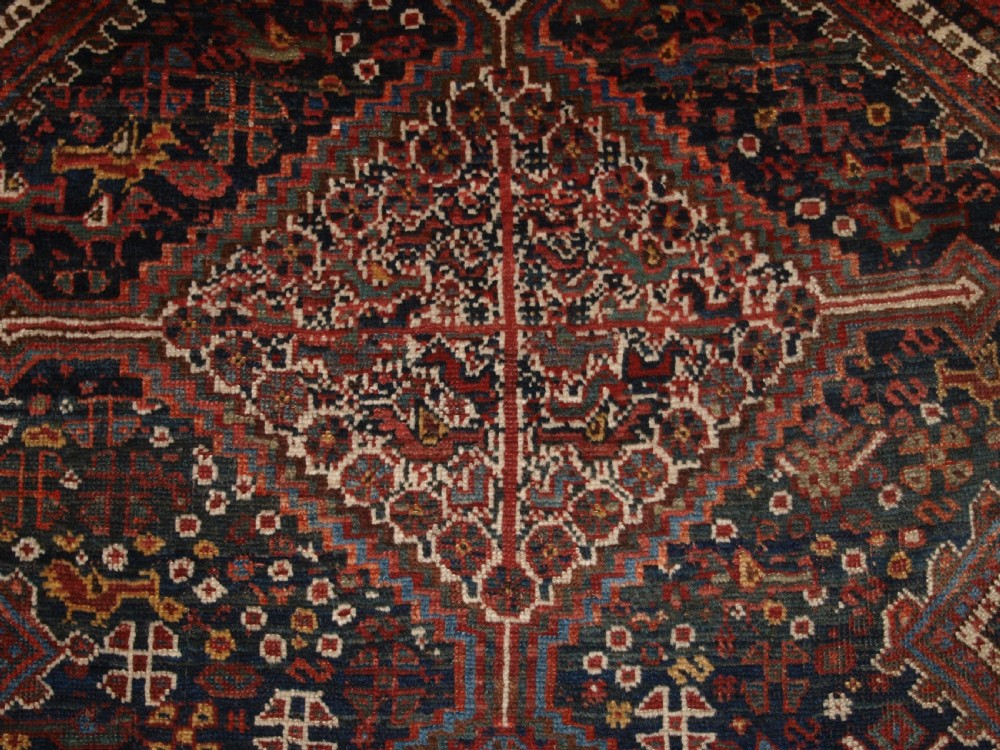 An antique hand-knotted Persian Khamseh wool rug featuring triple diamond medallions filled with stylized bird motifs on a dark navy and red geometric field. View VIII