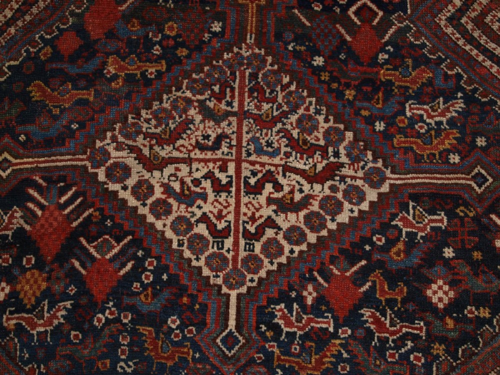 An antique hand-knotted Persian Khamseh wool rug featuring triple diamond medallions filled with stylized bird motifs on a dark navy and red geometric field. View X