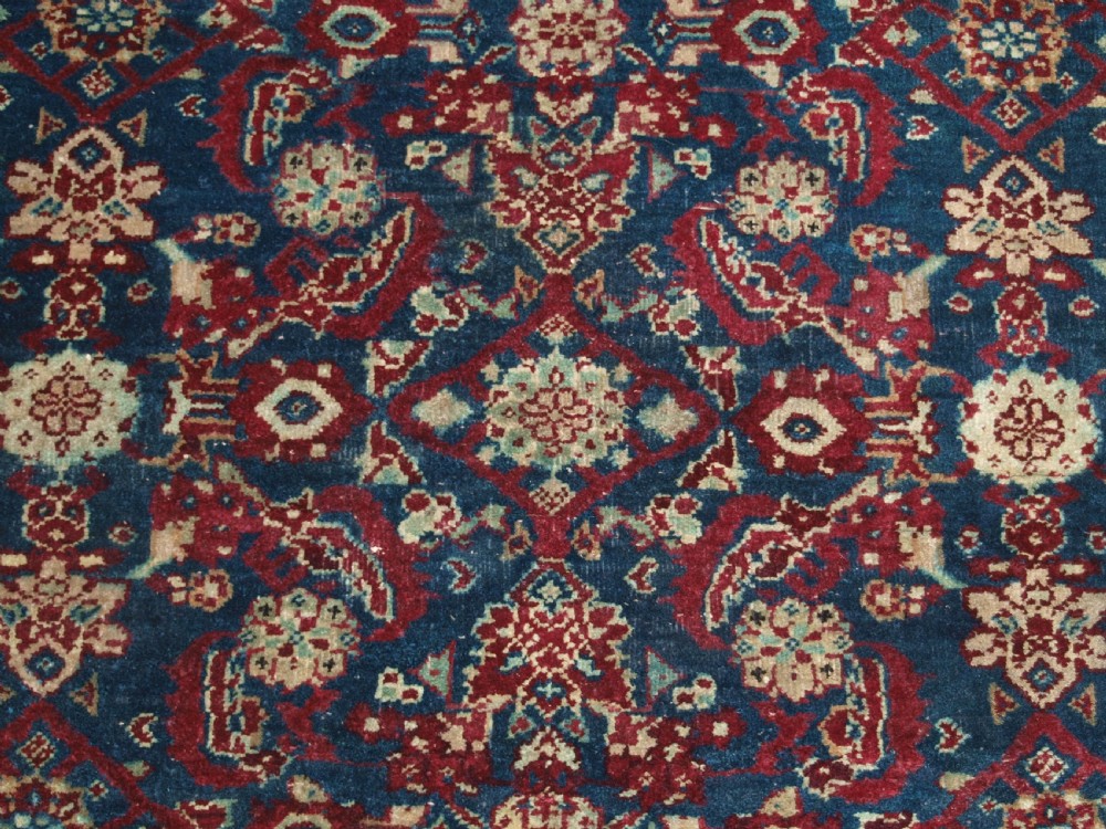 A late 19th-century hand-knotted Indian Agra carpet featuring an intricate all-over floral pattern on a deep blue field with a wide crimson border. View VII