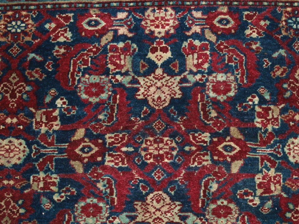 A late 19th-century hand-knotted Indian Agra carpet featuring an intricate all-over floral pattern on a deep blue field with a wide crimson border. View VIII