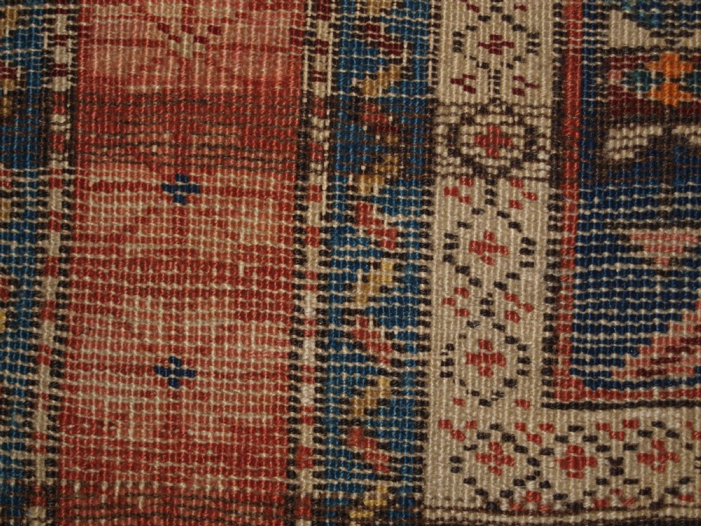 An antique hand-knotted Caucasian rug featuring a central navy blue field with a geometric star-and-lattice pattern framed by a reddish-pink patterned border. View XI