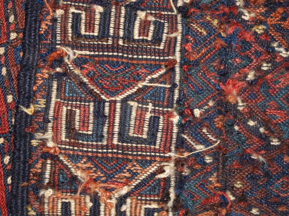A long handwoven rectangular Kurdish Soumak kilim rug featuring a dense red and blue diamond lattice pattern framed by a geometric meander border. View XIII