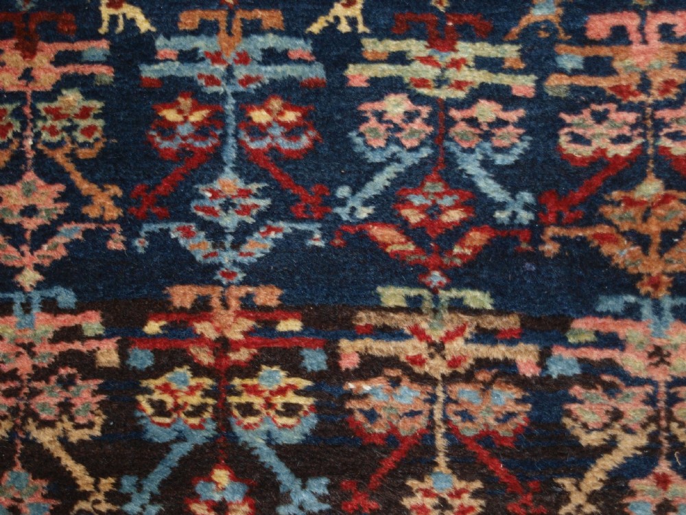 A long narrow antique Luri wool runner carpet with repeating colourful geometric tribal motifs on a dark indigo background framed by decorative multi-band borders. View VII