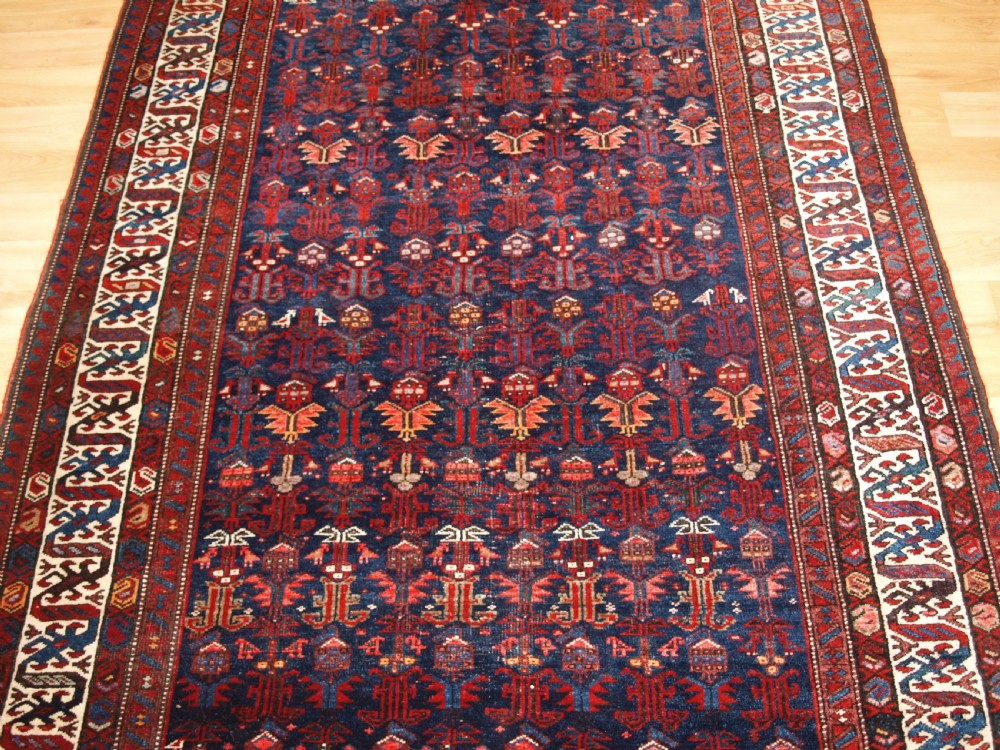 An antique hand-knotted Kurdish Kelleh long rug featuring a deep navy central field with geometric motifs enclosed by an ivory dragon pattern border. View II