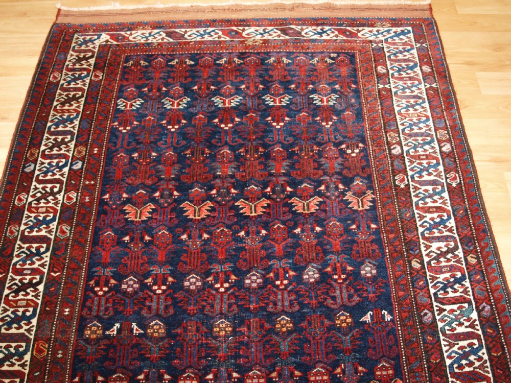 An antique hand-knotted Kurdish Kelleh long rug featuring a deep navy central field with geometric motifs enclosed by an ivory dragon pattern border. View III