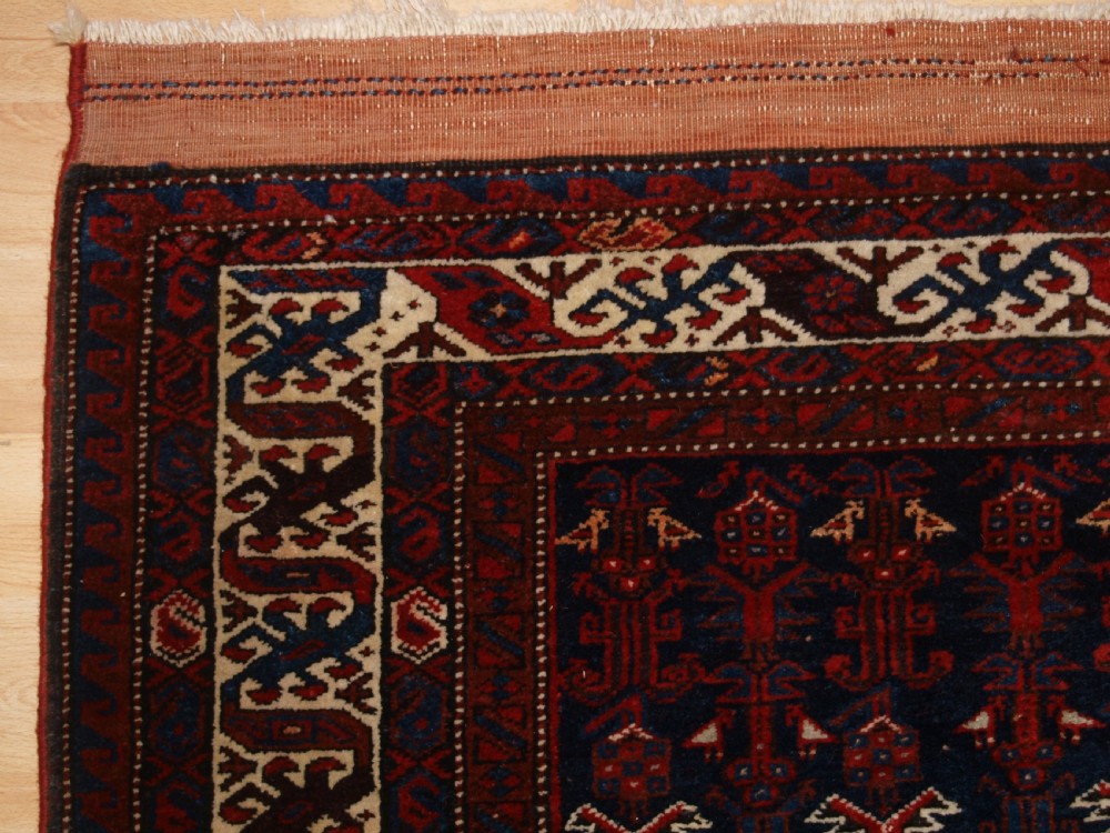 An antique hand-knotted Kurdish Kelleh long rug featuring a deep navy central field with geometric motifs enclosed by an ivory dragon pattern border. View IV