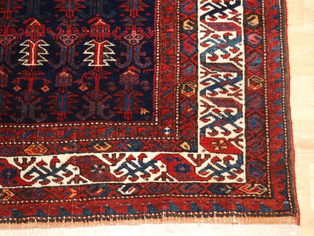 An antique hand-knotted Kurdish Kelleh long rug featuring a deep navy central field with geometric motifs enclosed by an ivory dragon pattern border. View X