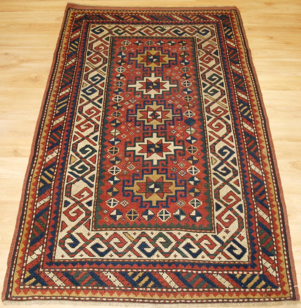 ANTIQUE CAUCASIAN KAZAK RUG WITH MEMLINC GULS, SMALL SIZE, CIRCA 1900.