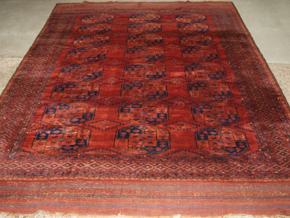 A large hand-knotted antique Ersari Turkmen carpet featuring octagonal gul motifs on a terracotta red wool field. View II