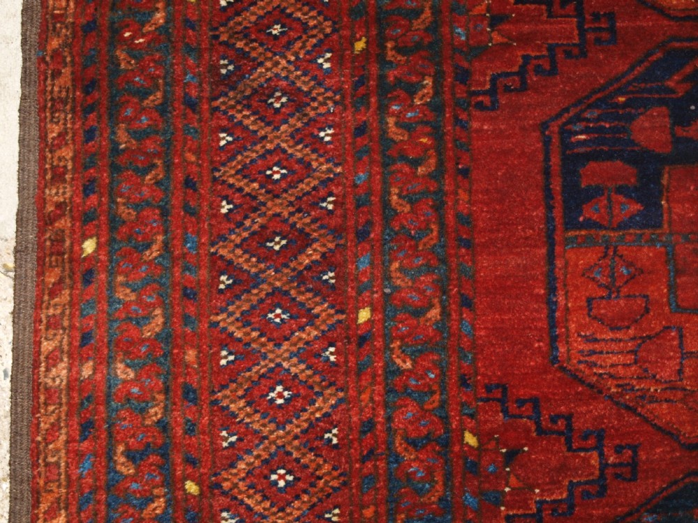 A large hand-knotted antique Ersari Turkmen carpet featuring octagonal gul motifs on a terracotta red wool field. View III