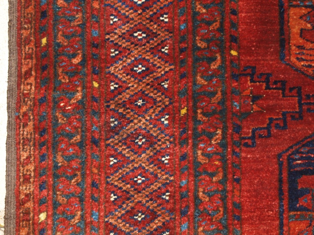 A large hand-knotted antique Ersari Turkmen carpet featuring octagonal gul motifs on a terracotta red wool field. View VII