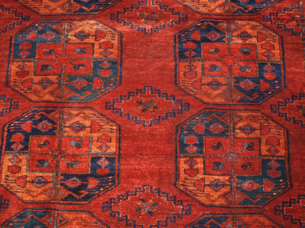 A large hand-knotted antique Ersari Turkmen carpet featuring octagonal gul motifs on a terracotta red wool field. View VIII
