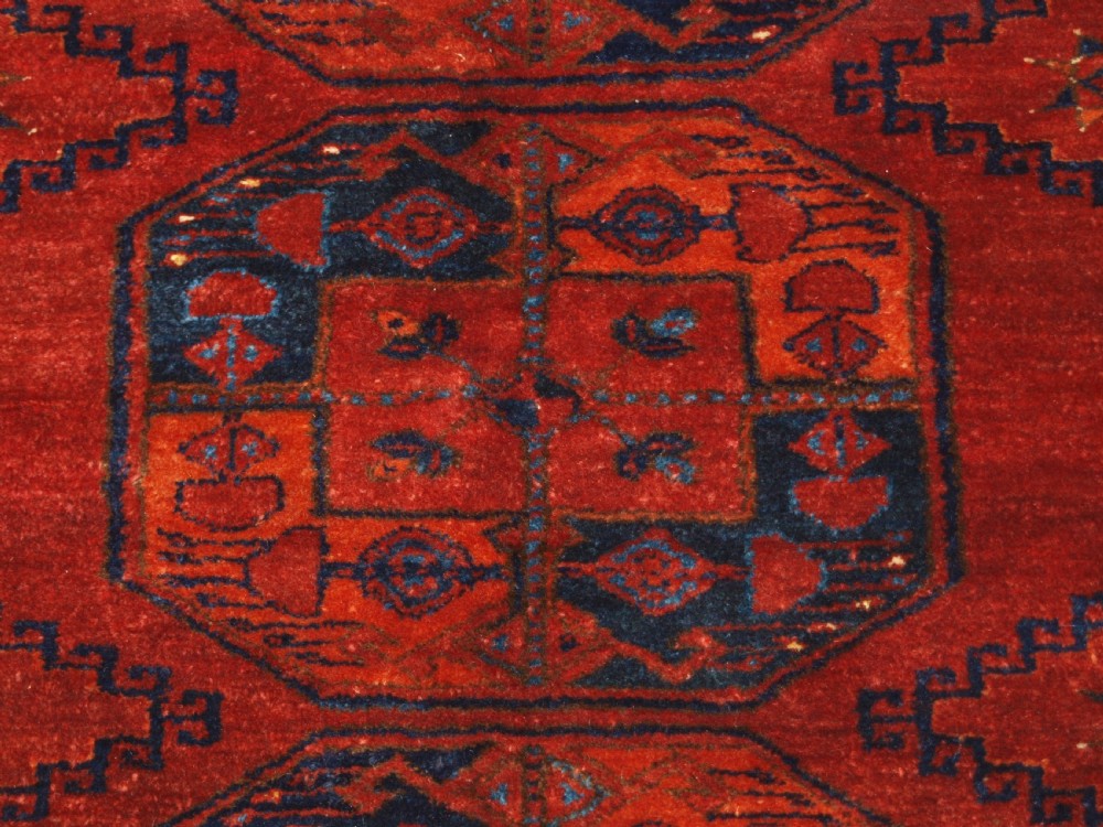 A large hand-knotted antique Ersari Turkmen carpet featuring octagonal gul motifs on a terracotta red wool field. View IX