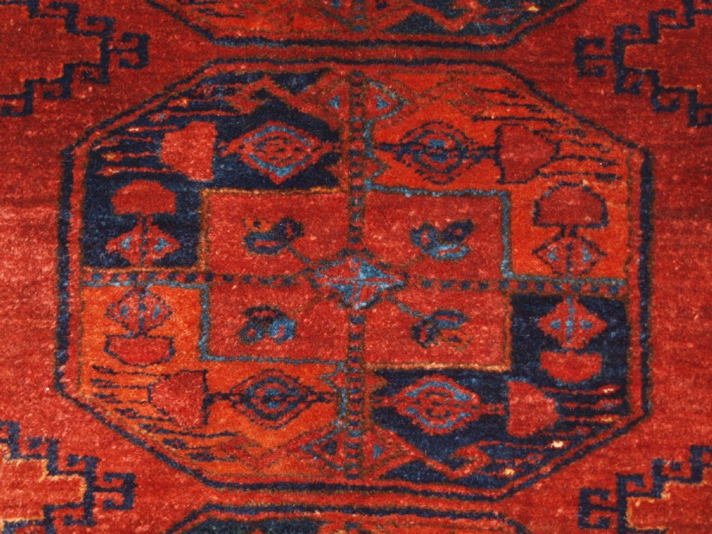 A large hand-knotted antique Ersari Turkmen carpet featuring octagonal gul motifs on a terracotta red wool field. View X