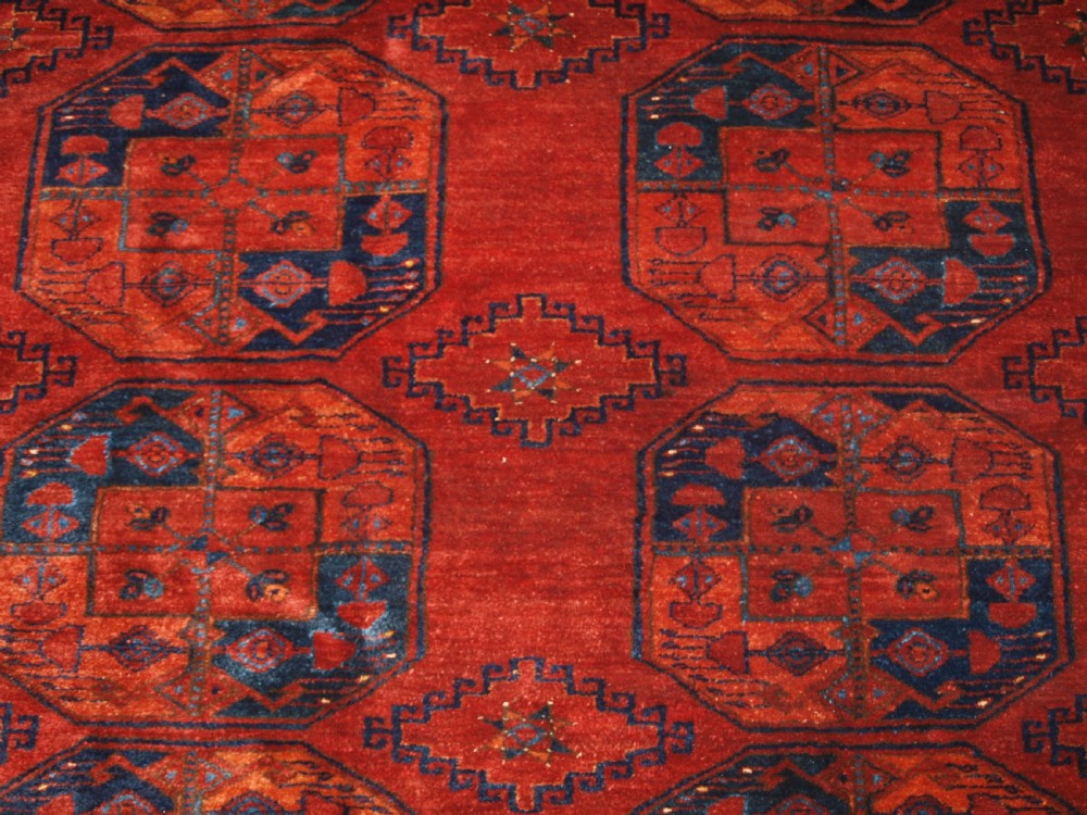 A large hand-knotted antique Ersari Turkmen carpet featuring octagonal gul motifs on a terracotta red wool field. View XII