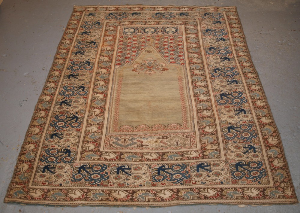 ANTIQUE TURKISH GHIORDES PRAYER RUG, GREEN GROUND, EARLY FORM, CIRCA 1750.