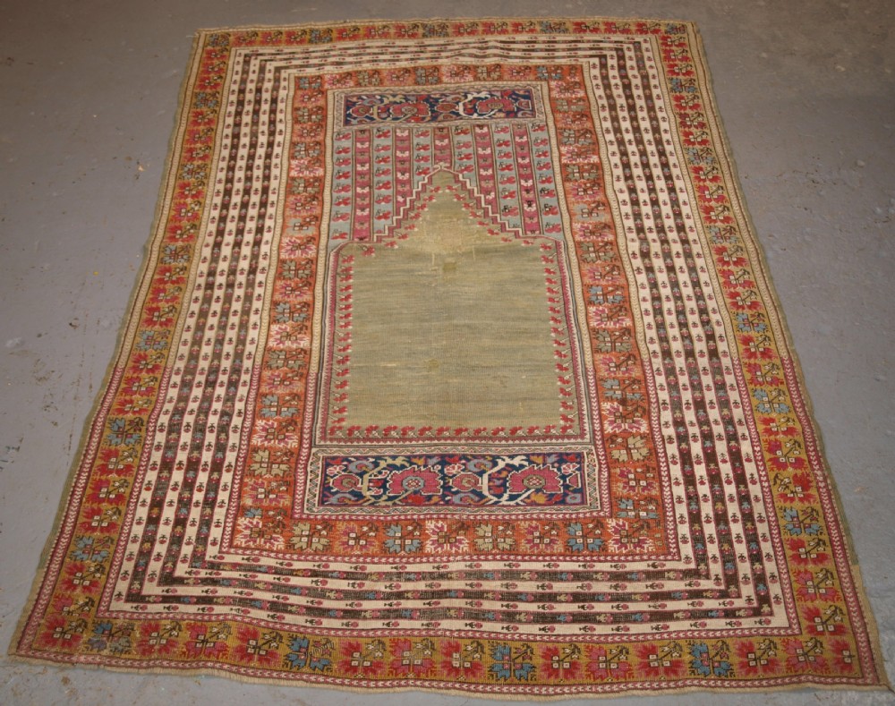 ANTIQUE TURKISH GHIORDES PRAYER RUG, MULTIPLE BORDERS, GREEN FIELD, CIRCA 1800.