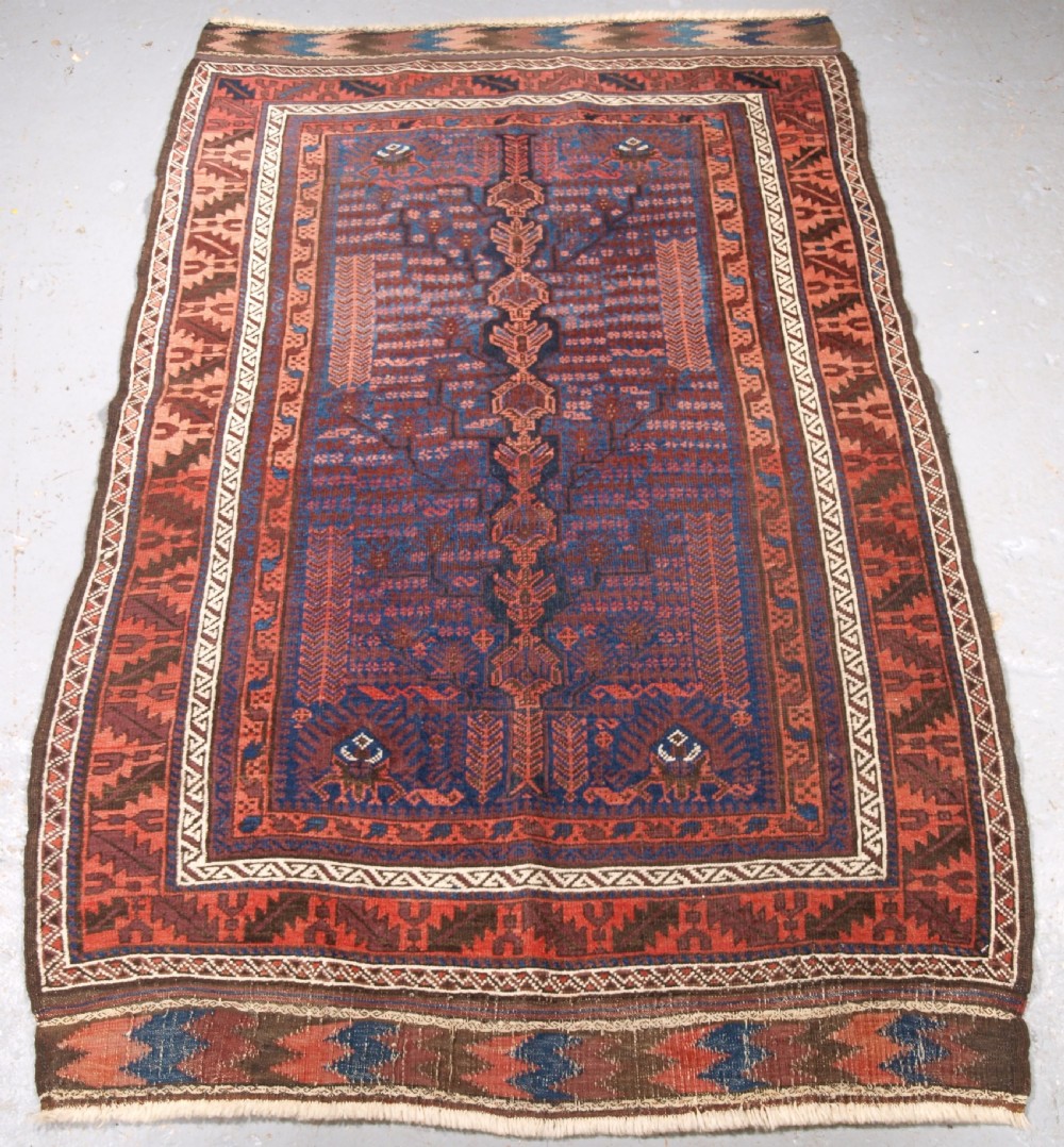 ANTIQUE TIMURI BALUCH RUG WITH BLUE GROUND AND TREE OF LIFE, CIRCA 1880.
