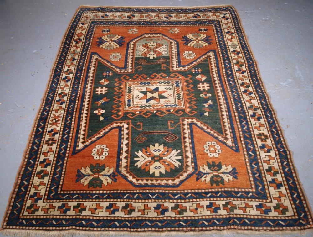 ANTIQUE CAUCASIAN SEWAN KAZAK RUG WITH GREEN GROUND MEDALLION, CIRCA 1890.