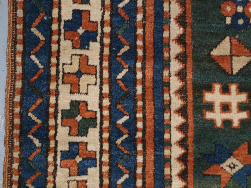 ANTIQUE CAUCASIAN SEWAN KAZAK RUG WITH GREEN GROUND MEDALLION, CIRCA 1890. View VII