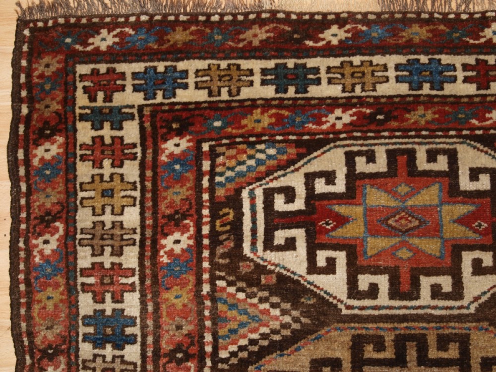 An antique hand-knotted Kurdish runner rug featuring a vertical sequence of octagonal Memling gul motifs in terracotta, blue, and cream shades. View II